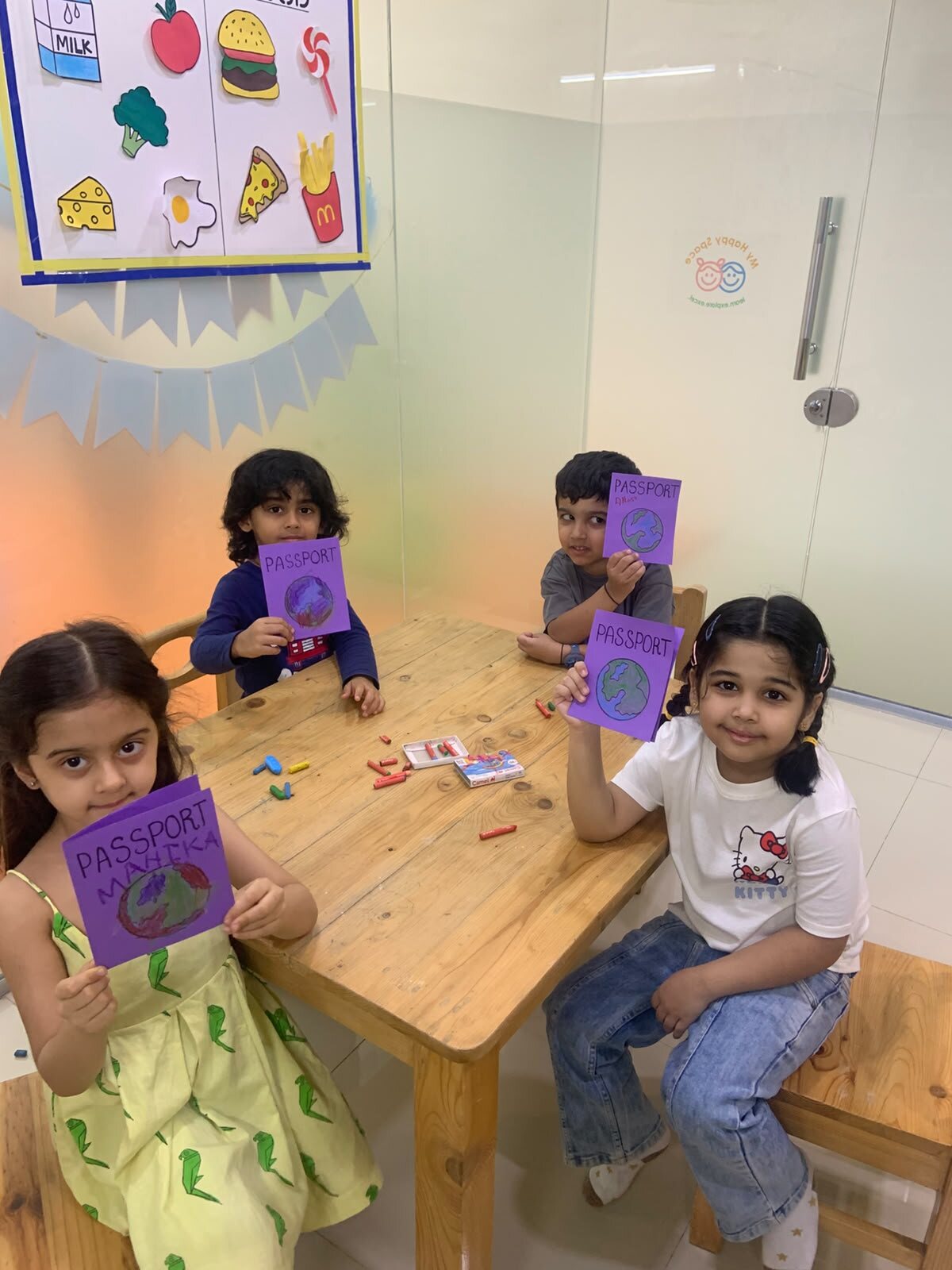 Children showing passport-themed classroom crafts